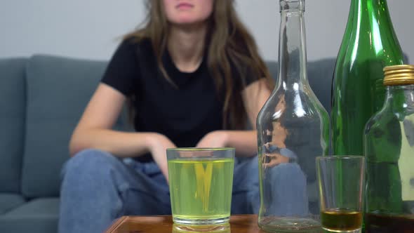 a woman suffers from a hangover, she drinks painkillers in a glass of water alt