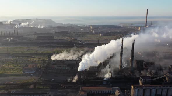Aerial view. White smoke from the chimneys of a steel mill