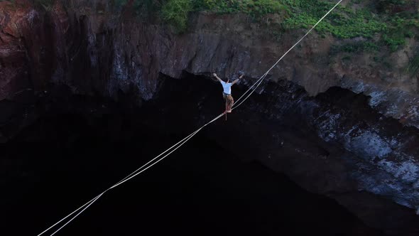 Aerial Footage of Man Walking on the Slackline Over the Massive Pit Film Grain alt