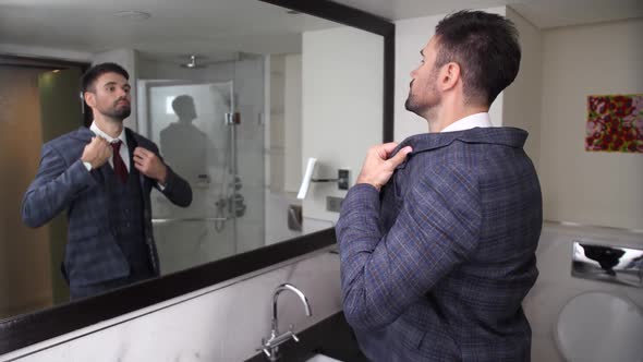 Businessman Putting on Jacket in Hotel Bathroom alt