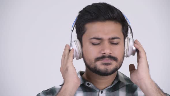 Portrait of Young Bearded Indian Man Listening To Music alt