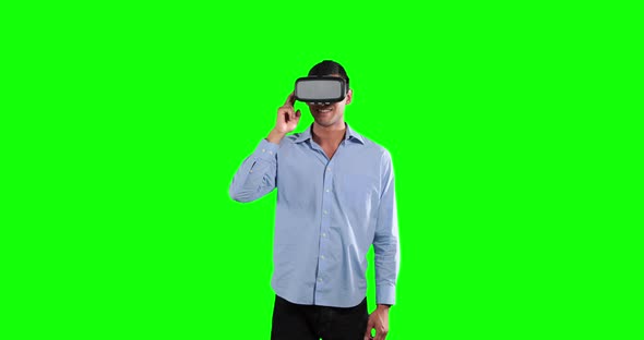 a Caucasian man wearing 3D goggles in a green background