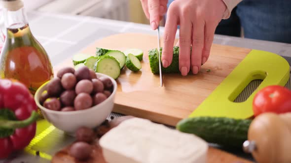 Greek Salad Preparation Series Concept  Woman Cutting Cucumbers alt