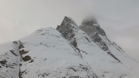 Aerial drone shot rotating around snow covered Otertinden mountain in Troms, Finnmark. Northern Norw alt