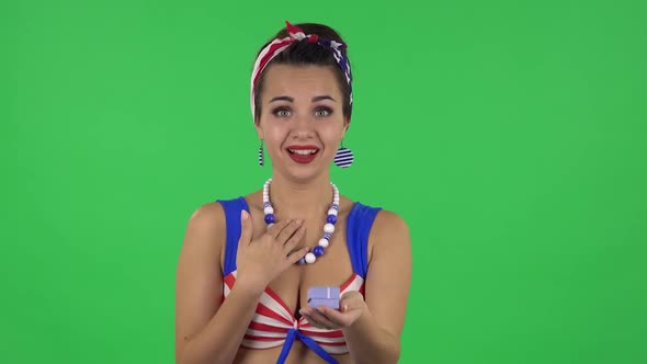 Portrait of Beautiful Girl in Swimsuit Is Opening Small Box with Surprise and Rejoicing. Greenscreen alt