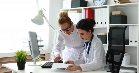 Female Smiling Doctors Looking at Camera in Light Office