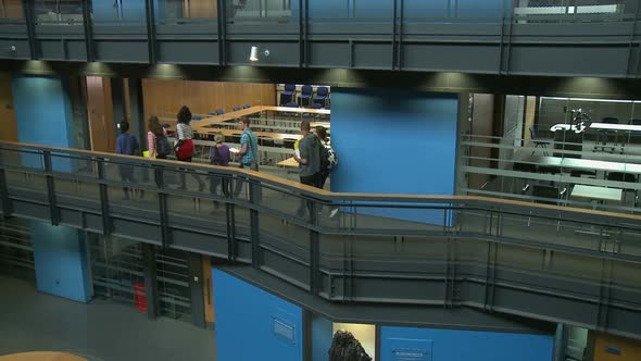 Students walking into classroom and sitting down alt