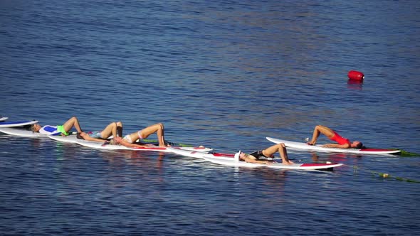 Group of Young Womens in Swimsuits Doing Yoga and Pilates on Sup Board in Calm Sea Early Morning alt