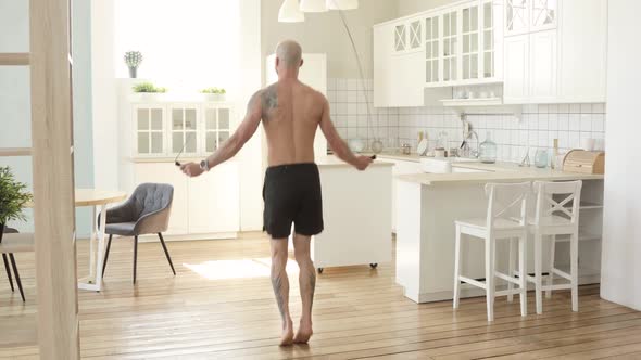 Muscular Sporty Man Is Jumping Rope Making Cardio Training at Home in Kitchen
