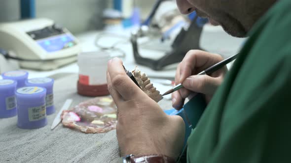 Technician applying ceramics to a dentition mold alt