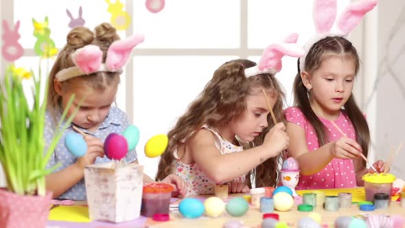Happy Children Wearing Bunny Ears Painting Eggs on Easter Day