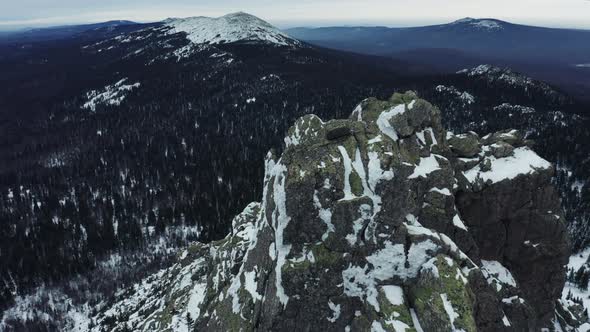 Aerial view of mountain range in winter day, drone moves down