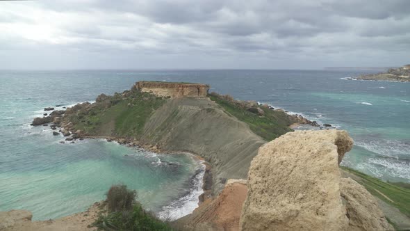 Panoramic View of Il-Qarraba Rock and Ghajn Tuffieha Bay on Cloudy Windy Day in Malta alt