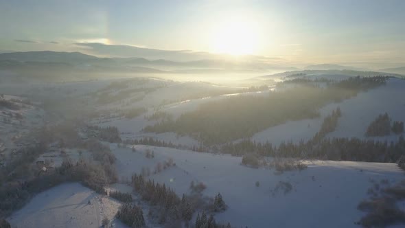 Flight Over a Village in Carpathian Mountains. Bird's Eye View of Snow-covered Houses in Mountains alt