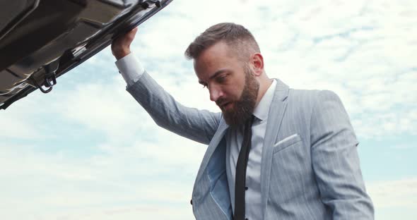 Sad Business Man Opening Car Hood and Looking at Breakdown Outdoo alt