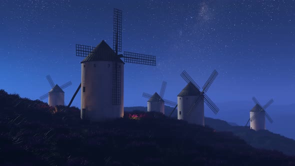 Multiple old, vintage, Spanish windmills rotating slowly at night. 4K HD