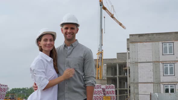 Portrait of Two Modern Architects in White Helmets Looking at the Camera Posing Against the alt