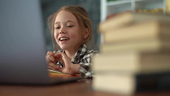Closeup of Smiling Primary Child School Girl Talking to Online Teacher While Studying Online on alt
