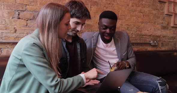 Happy friends working together with a laptop on a break alt