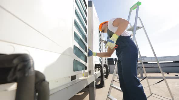 The Engineer is Making an Inspection of the Air Conditioning System alt