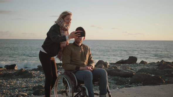 Male Wheelchair User and His Female Friend Are Taking Selfie By Smartphone alt