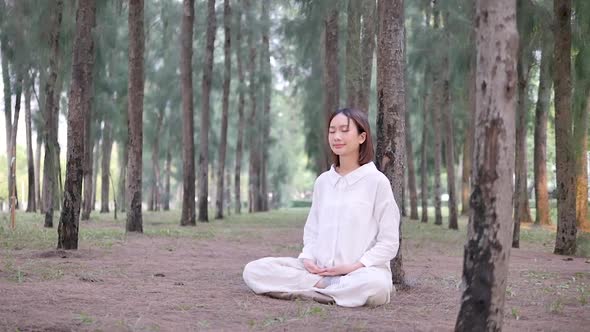 Asian woman meditating in a natural place