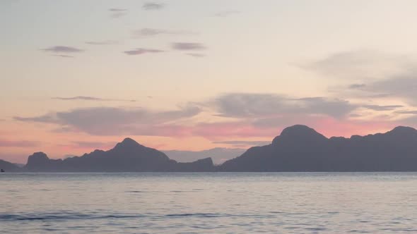 Slow motion shot of colorful sunset skies behind limestone cliffs in the ocean in Asia alt