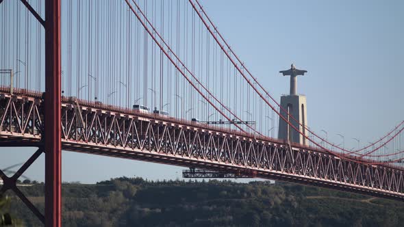 The Beautiful Abril Suspension Bridge In Portugal By The Large Statue Of Jesus Christ