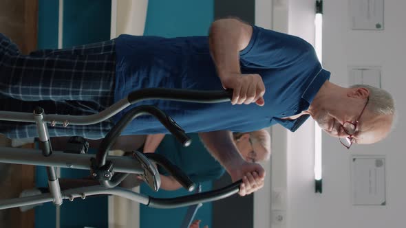 Vertical Video Portrait of Senior Patient Using Stationary Bicycle for Recovery Program alt