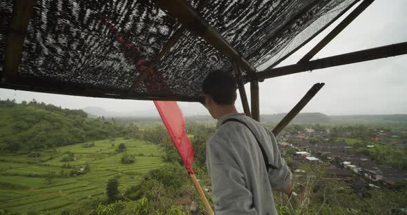 Close Up Handheld View of a White Male in Wildlife Observation Hut in the Rain Overlooking a alt