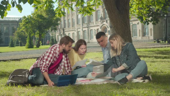 Blond Caucasian Woman Showing Something on Tablet To Interested Groupmates. Male and Female Students alt