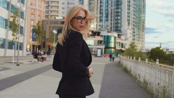 Beautiful Business Woman Blond In Glasses Walks Street Of The City alt