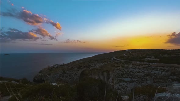Golden hour sunset over ocean from Blue Grotto, Malta, time-lapse alt