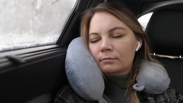 A Girl Rides in the Car Sleeps with Headphones in Her Ears