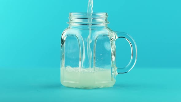 Fruit Fizzy Lemonade Soda Cold Beverage Drink Pooring Into Glass Jar Mug Blue  alt