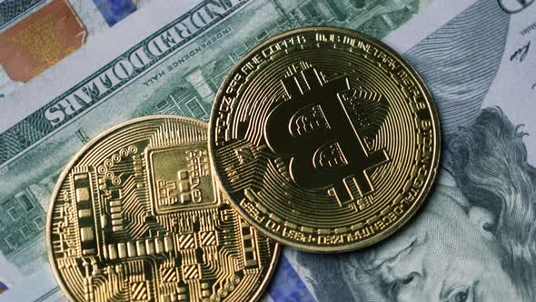 Bitcoin BTC coin rotate on 100 dollars USD bills. blockchain, mining GPU alt