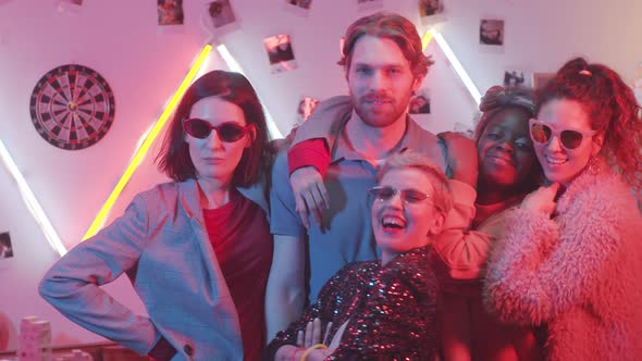 Handsome Man Posing for Camera with Glamorous Ladies at Home Party alt