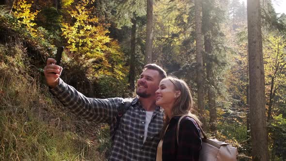 Happy People are Taking Selfie By Smartphone in Picturesque Autumn Forest alt
