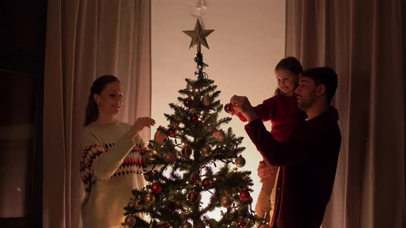 Happy Family Decorating Christmas Tree at Home