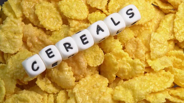 Crispy hot corn flakes rotating with smoke close up, dry healthy breakfast. Honey cornflakes alt