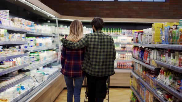 Couple Pushing Shopping Cart in Supermarket Rare View alt