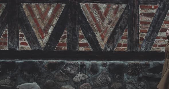 Young Woman Passing Old Building alt