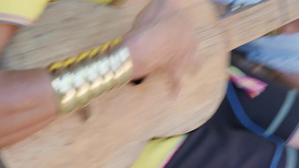 Close-up of an elderly Karen woman playing traditional guitar in local shop in northern Thailand. alt