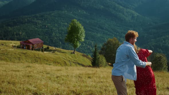 Young Family Dance Together in Summer Mountains alt