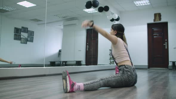 Caucasian female dancer choreographer stretching up on the floor of a dance studio alt