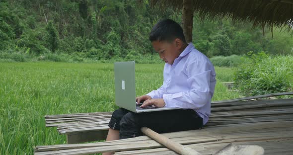 Poor Boy Using Laptop Computer alt