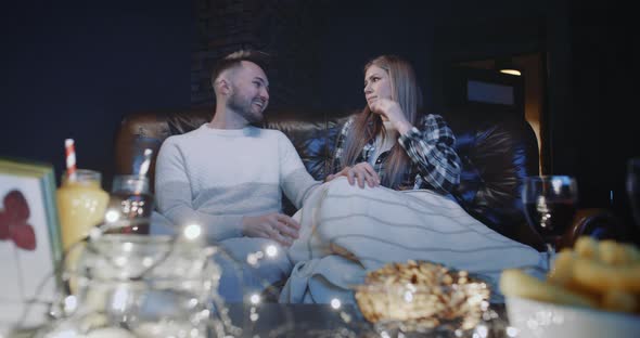Young Couple Man and Woman Watching a Horror Movie on TV in Evening at Home Watch Scary Video in alt