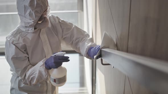 Video of a person in clean suit disinfecting a handrail, Shot with RED helium camera in 8K alt