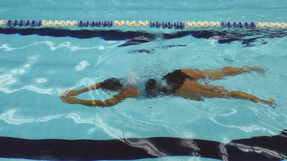 Young Female Swimmer Training Breaststroke In Swimming Pool