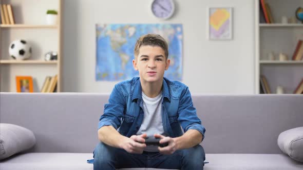 Teenage Boy Playing Video Game, Strong Emotional Reaction, Awkward Age alt